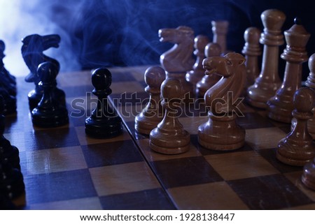 Wooden chess is a board game. Chess pieces on a dark background in smoke
