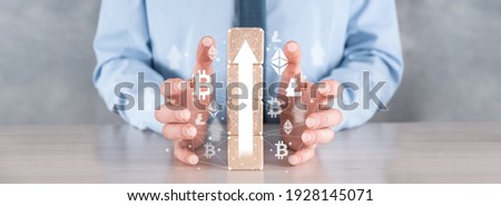 Businessman in a shirt holds in his hands wooden cubes with an arrow, a symbol of growth. Growth of cryptocurrencies, bitcoin, etherium and other currencies.Banner.