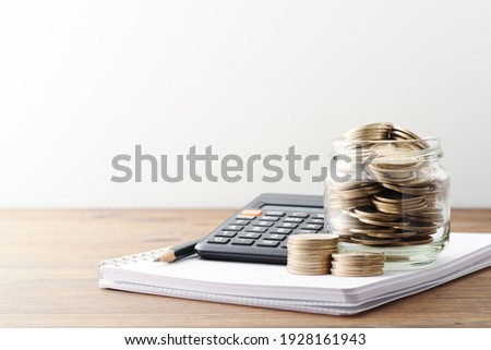 Money and calculator. Calculating personal finance and saving money. Money in jar and household accounts book on wood table.
 Royalty-Free Stock Photo #1928161943