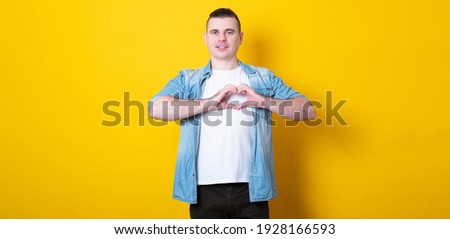 Man making a hand heart frame. Banner copy space.