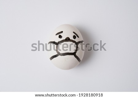 An egg with a face in a mask, on a white background. Quarantine concept covid 19.