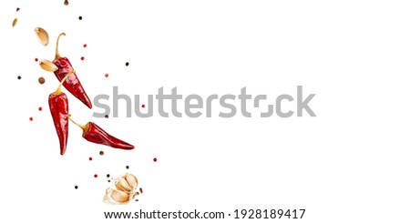 Flying  colorful spices peppers, chili, garlic  in the air isolated on white background. Food and cuisine ingredients top view, with copy space. banner. Royalty-Free Stock Photo #1928189417