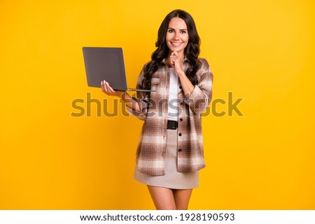 Photo portrait of thoughtful business woman working with computer smiling isolated on vivid yellow color background