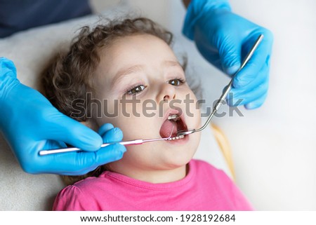 examination, treatment teeth children. medical checkup oral cavity with instruments. dental hands, child in office. Cute girl smiling stomatology. kid in dentist chair. concept health, medicine Royalty-Free Stock Photo #1928192684