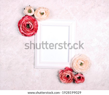 Festive romantic background with empty white frame, peony flowers on light marble. Top down composition with copy space for text or image. Valentine's Day, Mother's Day or 8 March greeting card.