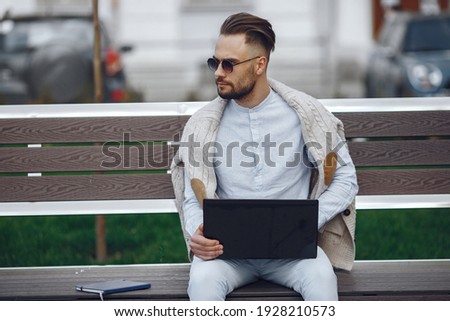 Man in a city. Businessman in a blue shirt. Student use a laptop;