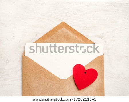 Blank notepad sheet for your congratulatory message. Close-up, view from above, wooden surface. No people. Concept of preparation for a professional holiday. Congratulations for relatives, friends and