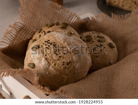 Homemade sourdough bread with pumpkin seed in a wooden tray on a wooden background. Selective Focus. Close Up