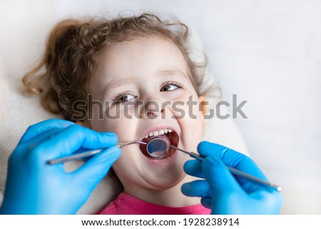 examination, treatment teeth children. medical checkup oral cavity with instruments. dental hands, child in clinic. Cute girl smiling stomatology. Happy kid in dentist chair. concept health, medicine Royalty-Free Stock Photo #1928238914