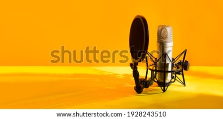 Professional microphone with waveform on yellow background banner. Podcast or recording studio background Royalty-Free Stock Photo #1928243510