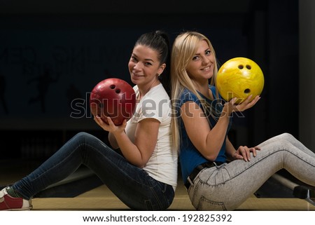Cheerful Young Couple Holding Bowling Ball
