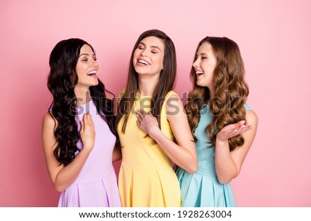 Portrait of three charming dreamy cheerful girls hugging talking laughing isolated over pink pastel color background Royalty-Free Stock Photo #1928263004
