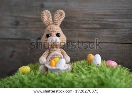 Easter knitted bunny and Easter eggs on green grass