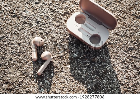 True wireless earbuds in case on natural stone background