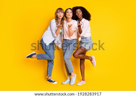 Full size portrait of three adorable persons arm palm send air kiss camera you isolated on yellow color background
