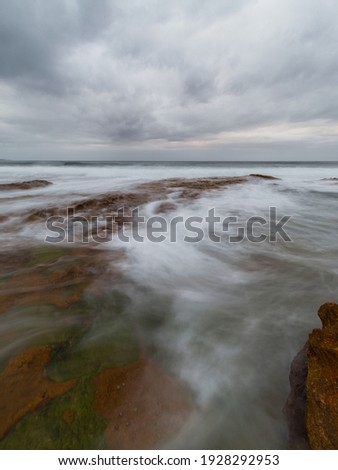 Water flowing into rock platform on the shore.