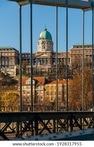Buda royal castle framed with part of Szecheny chain bridge. This place is a famous attraction in Budapest Hungary. Oldest bridge in the city.  Royalty-Free Stock Photo #1928317955