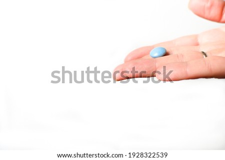 A pill or vitamin is in a woman's hand. Medical healthcare concept