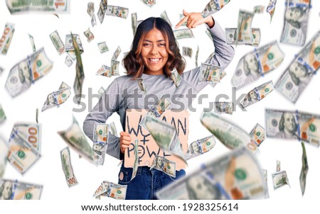 Young beautiful mixed race woman holding woman power banner pointing finger to one self smiling happy and proud
