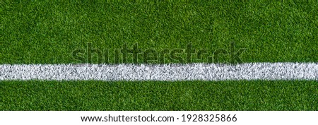 Green synthetic grass sports field with white line shot from above. Sports background for product display, banner, or mockup
