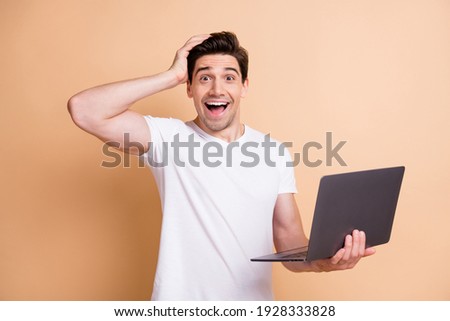 Photo of cheerful impressed man arm on head open mouth cant believe isolated on beige color background
