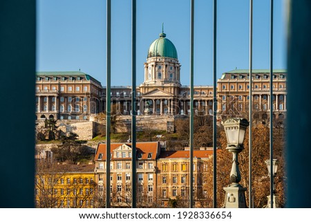 Buda royal castle framed with part of Szecheny chain bridge. This place is a famous attraction in Budapest Hungary. Oldest bridge in the city.  Royalty-Free Stock Photo #1928336654