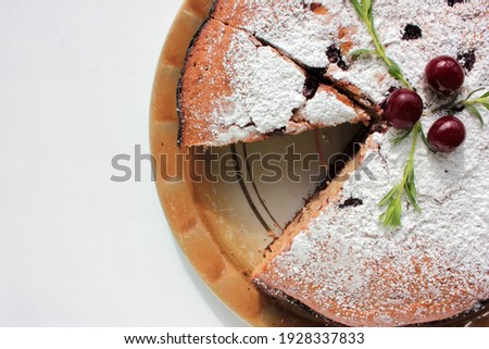 Pice of freshly baked cherry cake on white table background. Overhead view of homemade berry pie. Selective focus Royalty-Free Stock Photo #1928337833