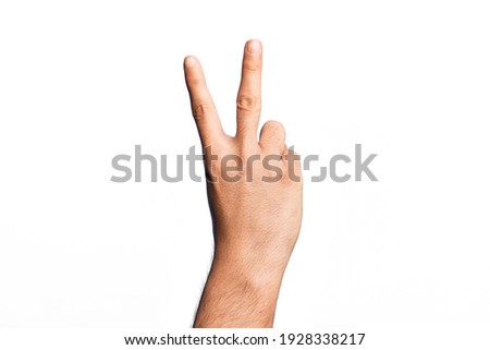 Hand of caucasian young man showing fingers over isolated white background counting number 2 showing two fingers, gesturing victory and winner symbol Royalty-Free Stock Photo #1928338217