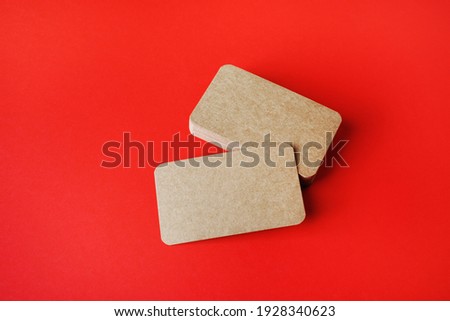 Blank kraft business cards on red paper background. Mockup for ID. Template for graphic designers portfolios.