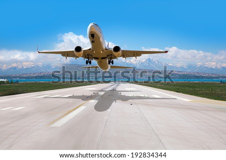 White Passenger plane fly up over take-off runway from airport - Commercial passenger airplane takes off from the runway Royalty-Free Stock Photo #192834344