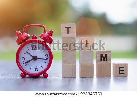 Red alarm clock and wooden block Financial concepts, savings, financial investment, accounting and stock markets are worth investing in.
