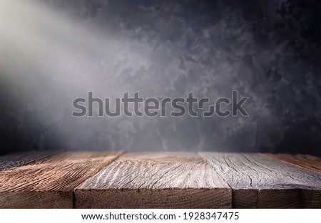 Empty wooden table top with defocused dark concrete wall background. Template for product display