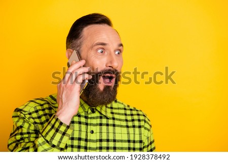 Profile side photo of excited man call talk speak cellphone amazed shocked surprised news rumor isolated over yellow color background