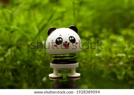 Panda toy in the garden. Natural background