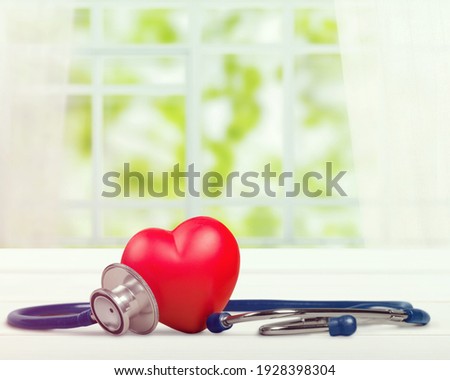 Single red heart and medical doctor stethoscope on desk Royalty-Free Stock Photo #1928398304