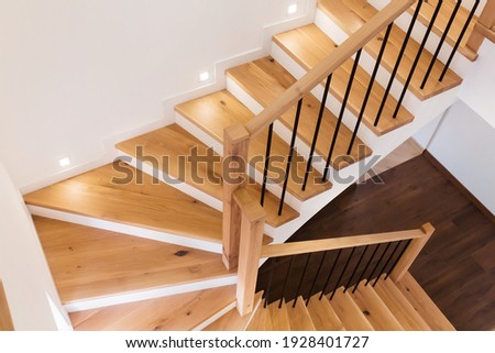 Wood staircase inside contemporary white modern house. Royalty-Free Stock Photo #1928401727