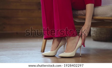 tired business woman takes off her shoes after a long day. swelling of feet after high heels, soft focus. Selective focus. Royalty-Free Stock Photo #1928402297