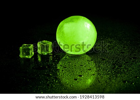 Green ice ball reflection on black background.