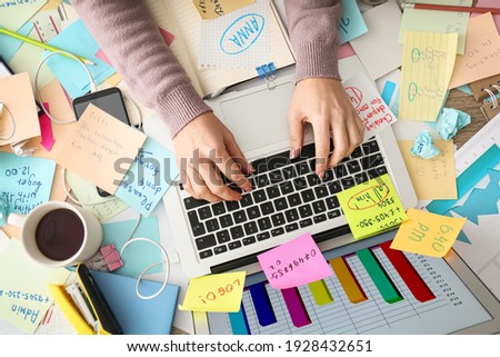 Overwhelmed woman working at messy office desk, top view Royalty-Free Stock Photo #1928432651