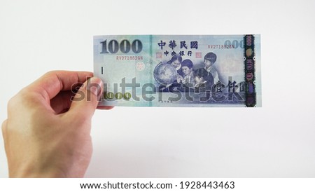 Asian man hand holding a Taiwan Dollar isolated on white background