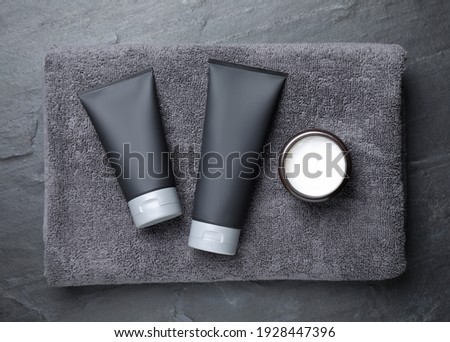 Set of men's cosmetic products with towel on grey stone table, top view