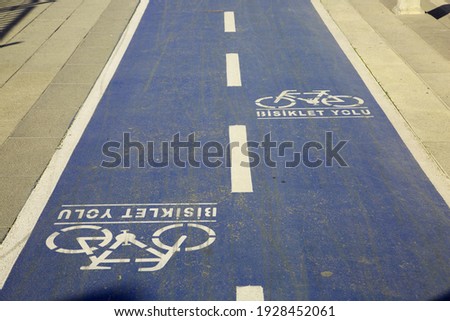 Horizontal shot of the bike path on a blue background. "Bicycle path" in Turkish is written on the ground.