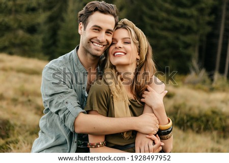 Loving young couple hugging and smiling together on nature background. High quality photo Royalty-Free Stock Photo #1928497952