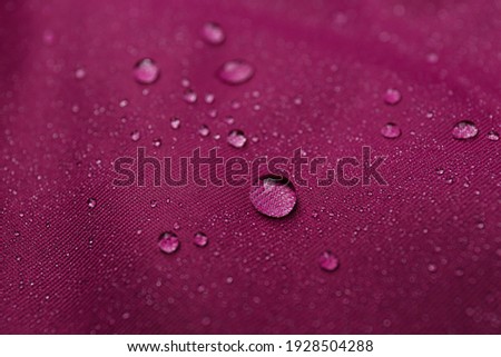 Dark pink waterproof fabric with water drops as background, closeup Royalty-Free Stock Photo #1928504288