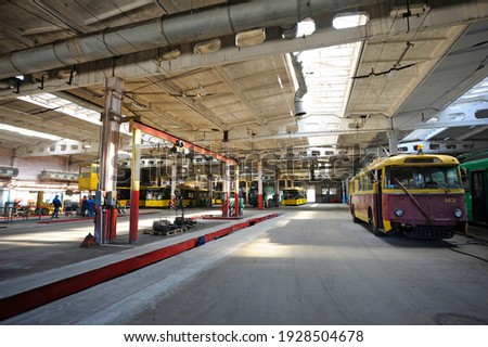 An old but still in use trolleybus parked on the inspection pit at the trolley depot. Hangar of depot maintenance. Royalty-Free Stock Photo #1928504678
