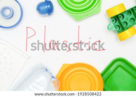Sign plastic surrounded with many pet plastic objects, things bottles toys caps that can be recycled in order to save nature and protect environment.