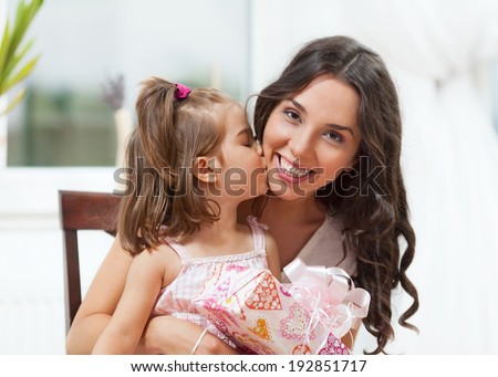 Beautiful young woman with her daughter showing love and affection. Mother's Day