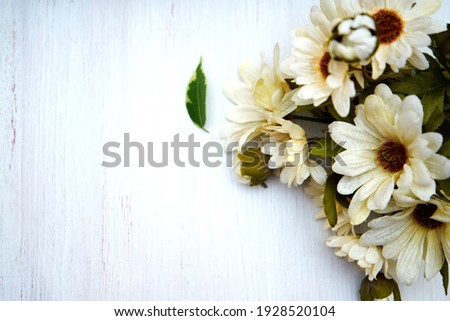 Artificial daisy flowers white wooden background.  Background for holidays. CopySpace