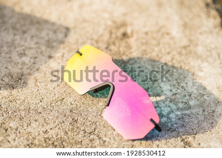 Futuristic sunglasses model rimless with pink lenses reflecting the sun in a summer day shoot outside closeup. Selective focus 
