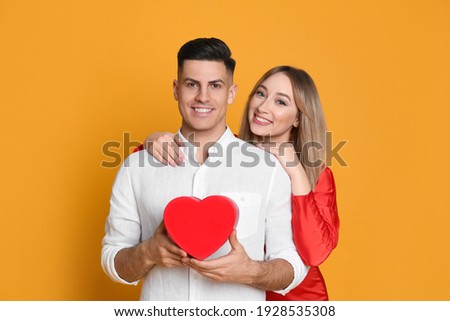 Lovely couple with decorative heart on yellow background. Valentine's day celebration